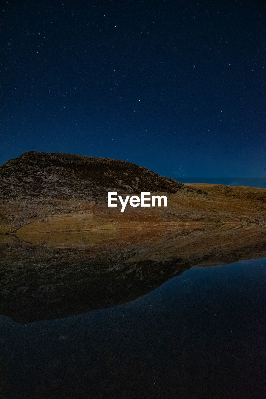 Scenic view of mountains against blue sky