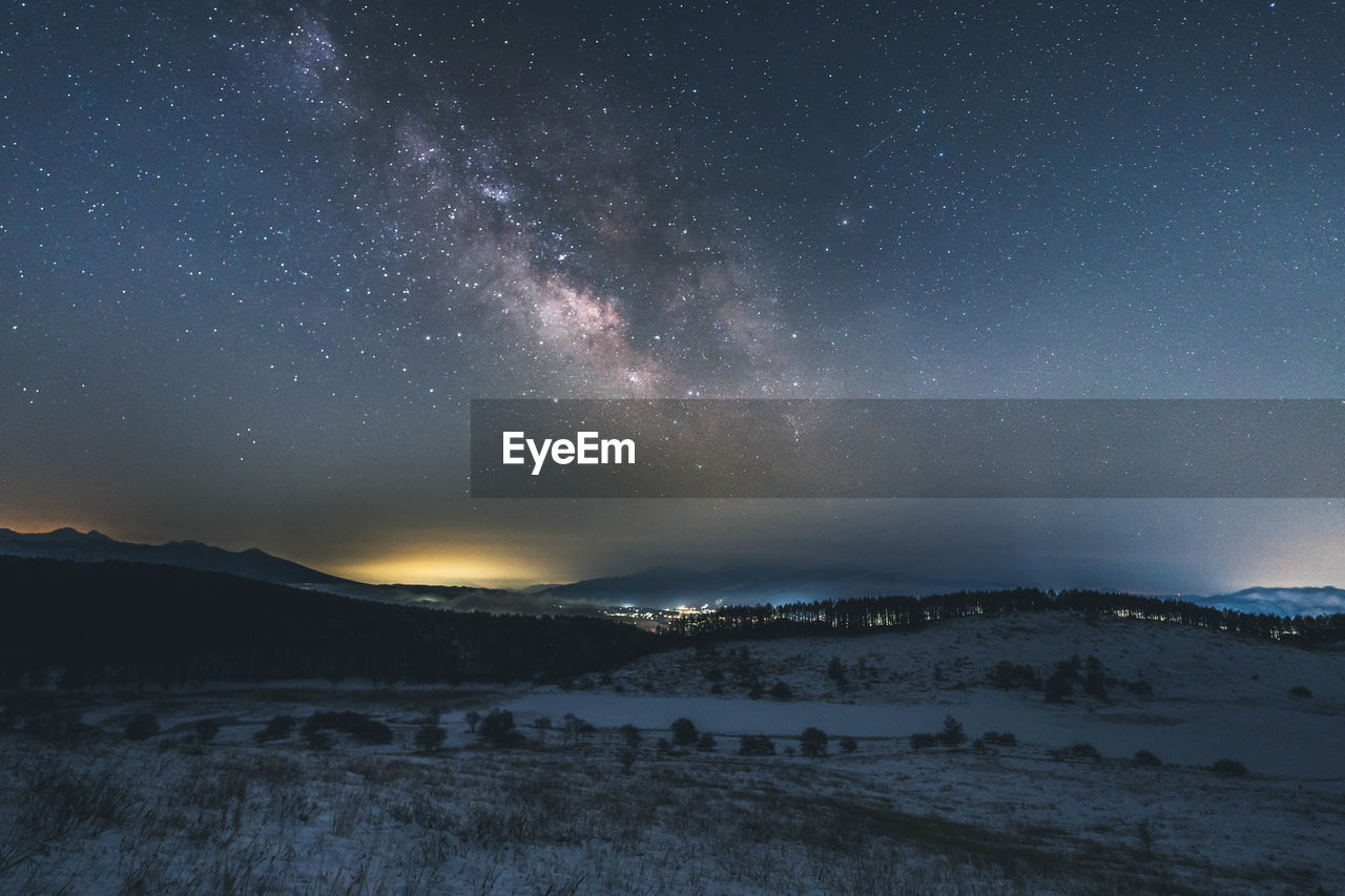 Scenic view of snowcapped mountains against sky at night