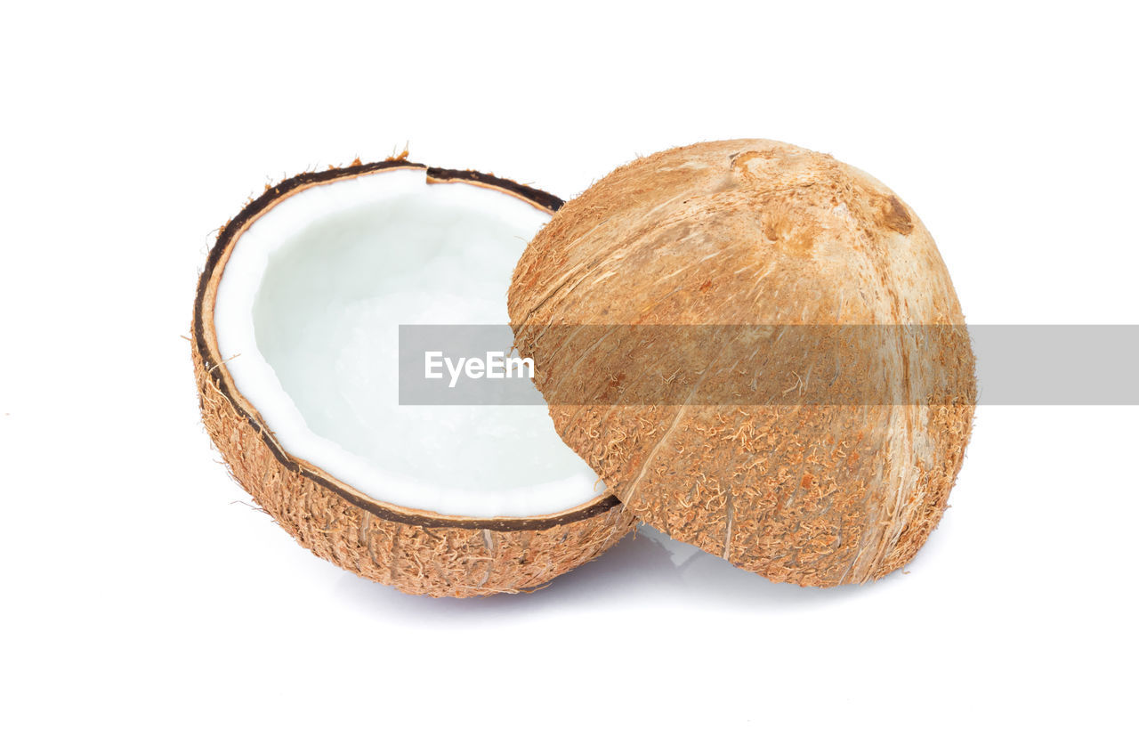 Close-up of halved coconut on white background