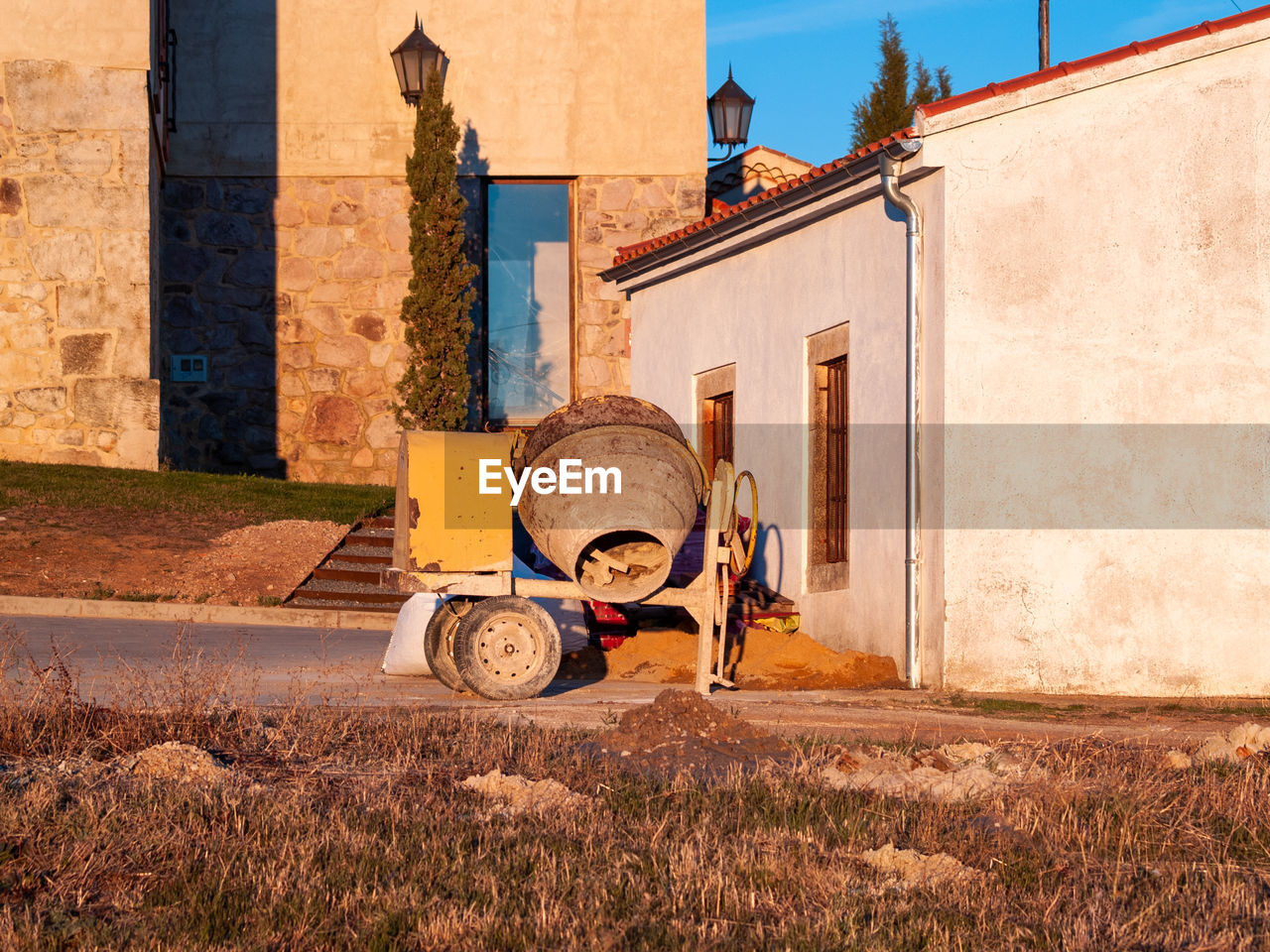 WOMAN ON ROAD BY BUILDINGS