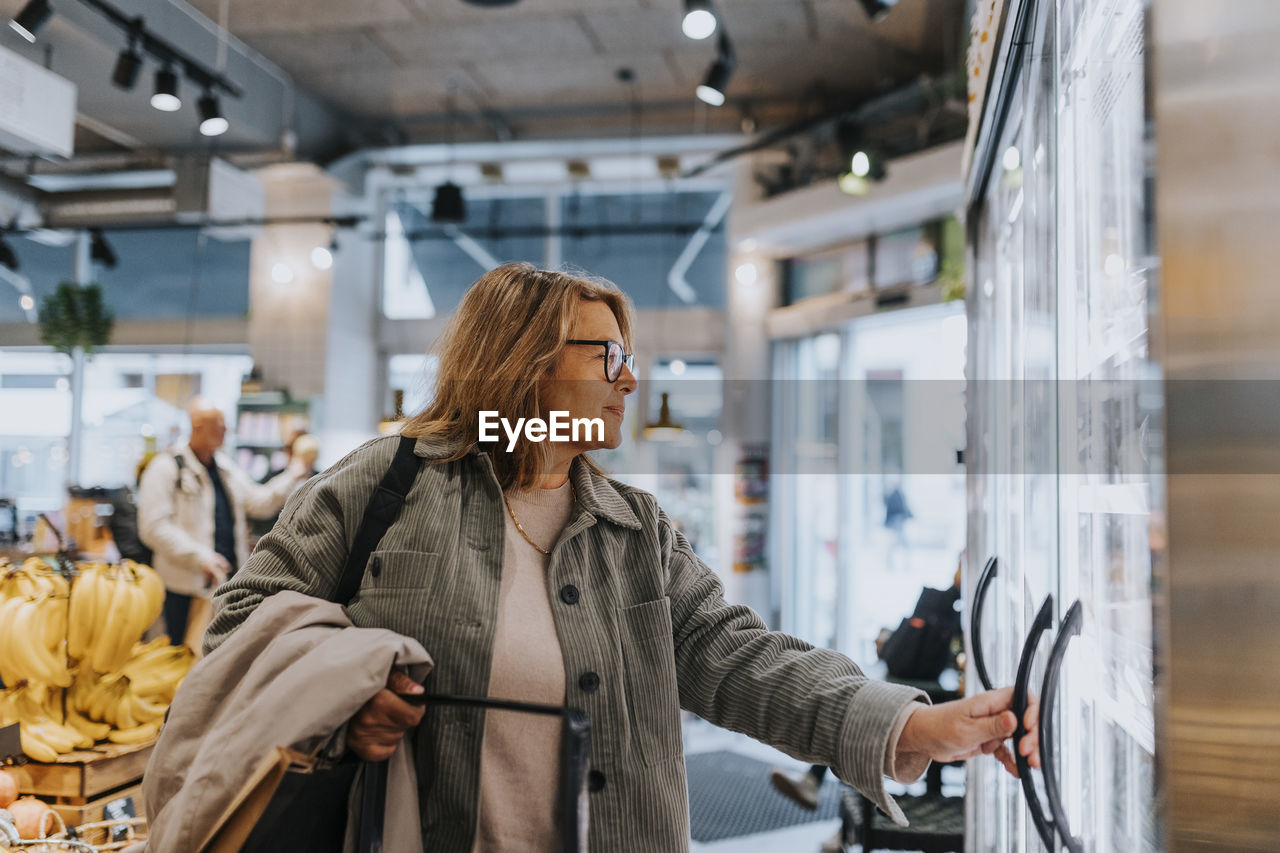 Smiling senior woman doing shopping in supermarket