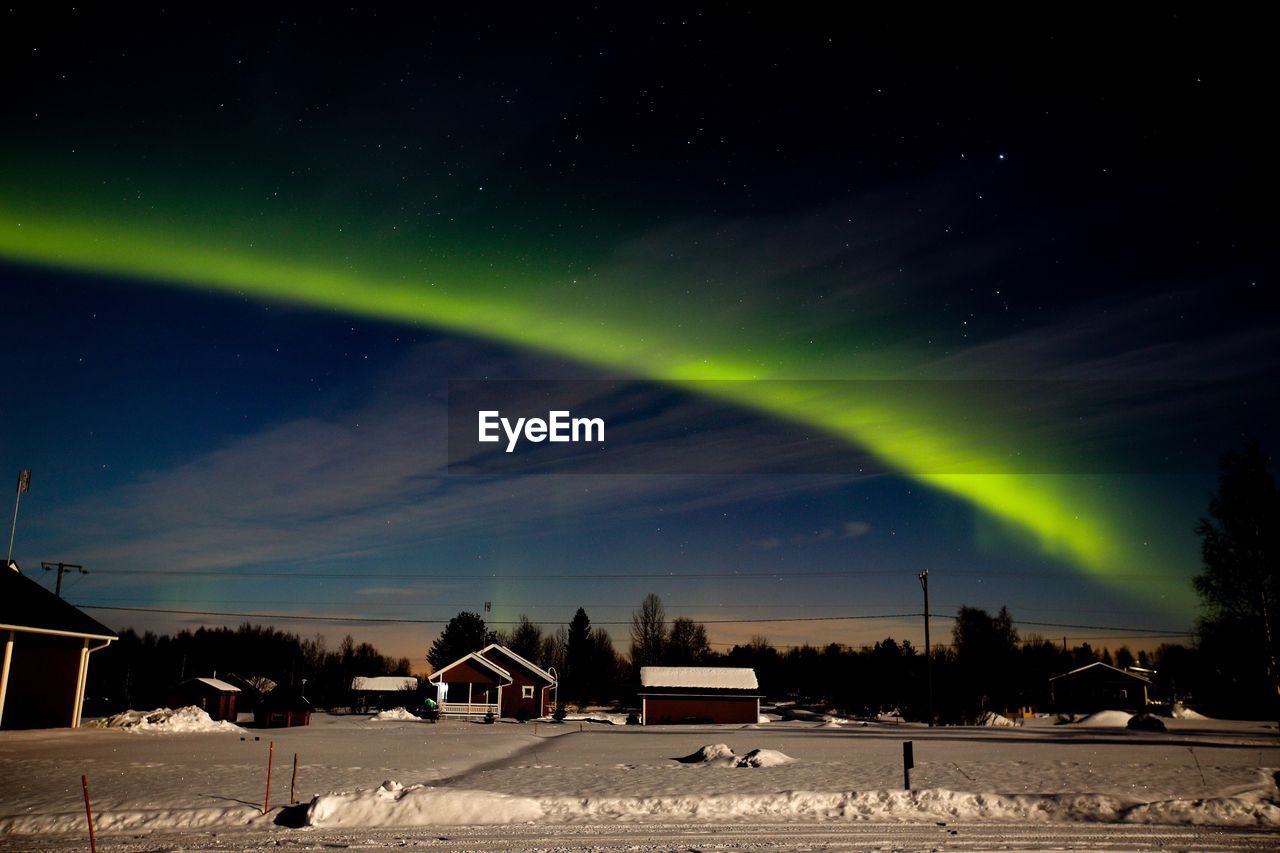 Low angle view of aurora borealis in sky at dusk