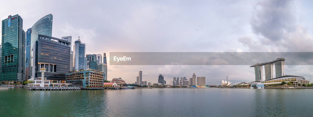 Buildings in city against cloudy sky