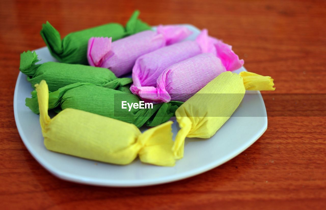 Close-up of multi colored candies in plate on table