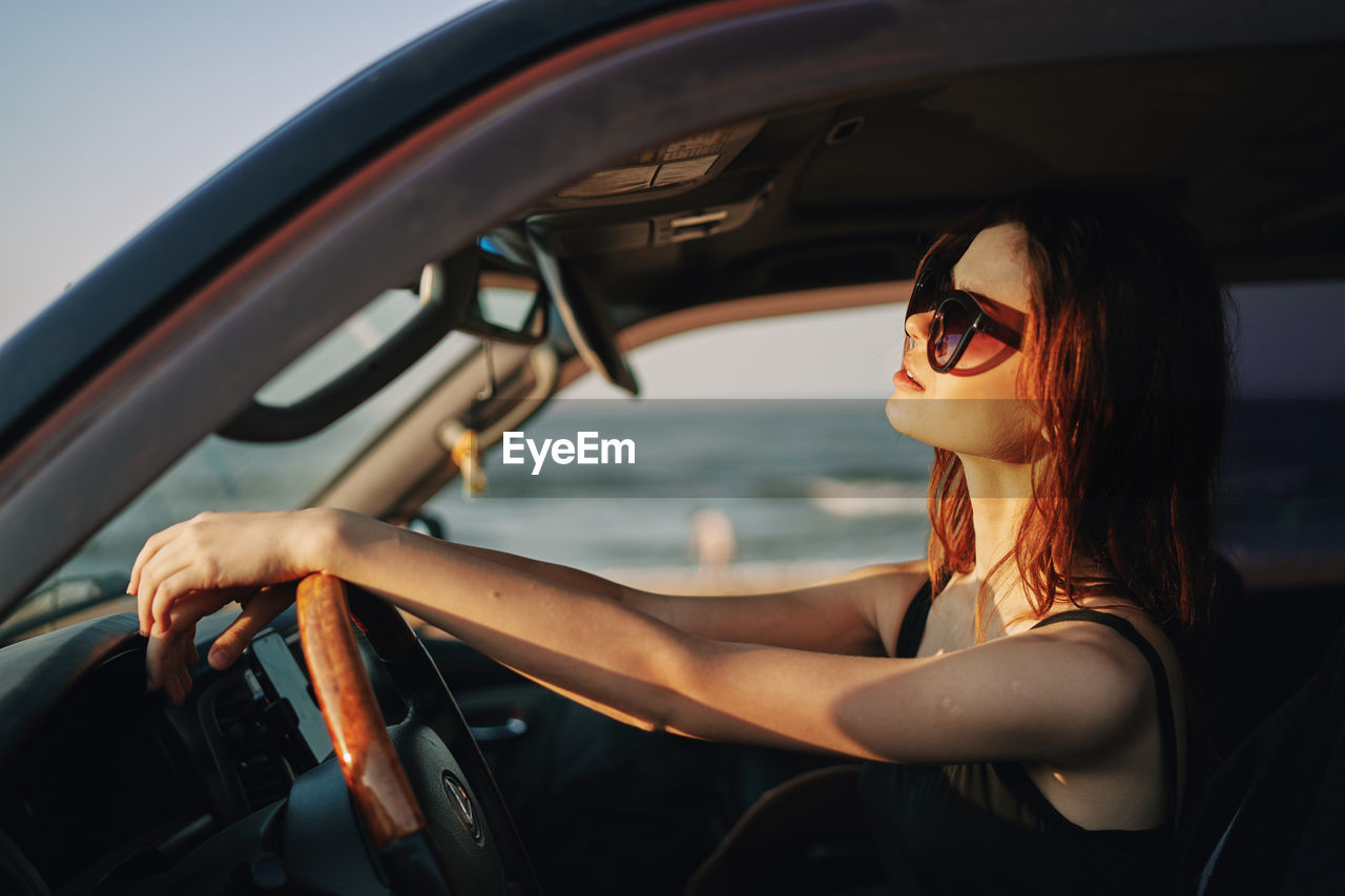 Woman wearing sunglasses sitting in car