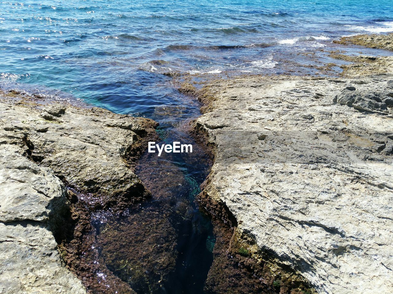 HIGH ANGLE VIEW OF ROCK FORMATIONS ON SHORE