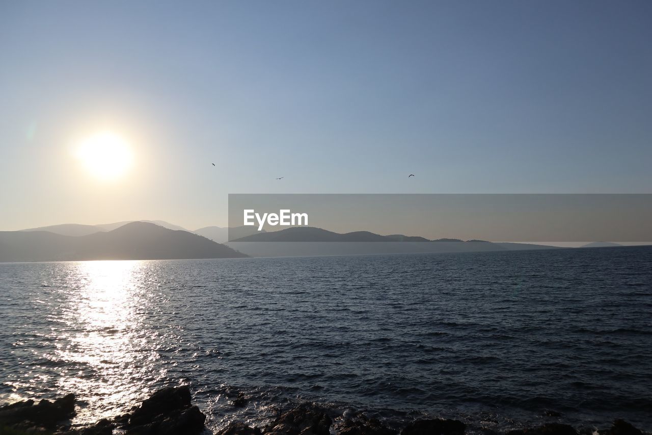 SCENIC VIEW OF SEA AND MOUNTAINS AGAINST SKY