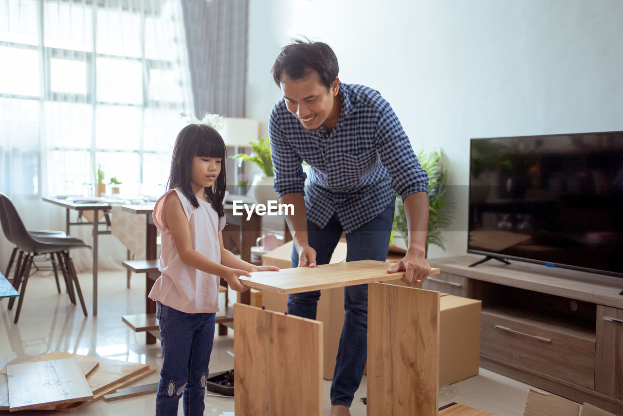 Father and daughter making furniture at home
