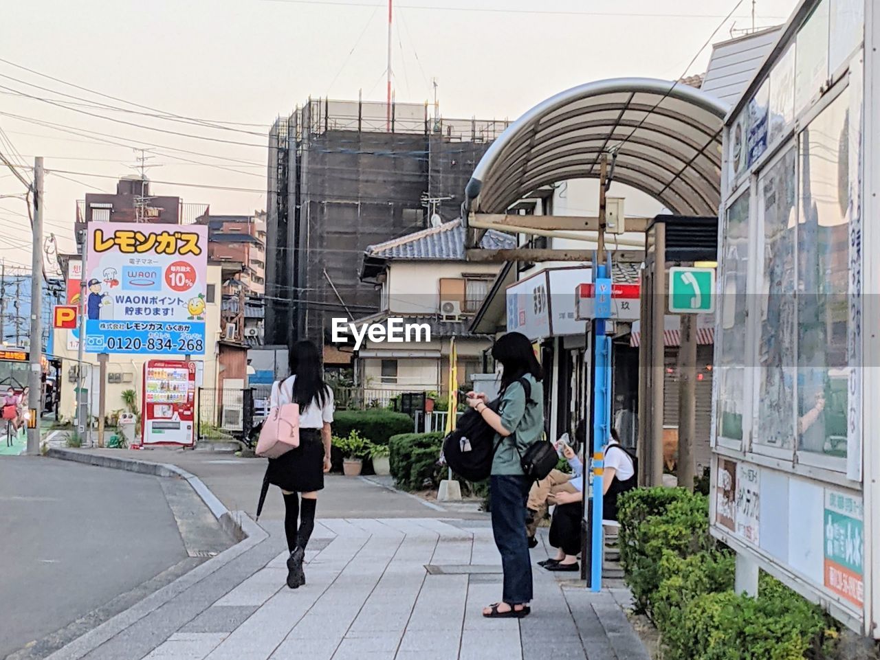 PEOPLE WALKING ON FOOTPATH BY BUILDINGS