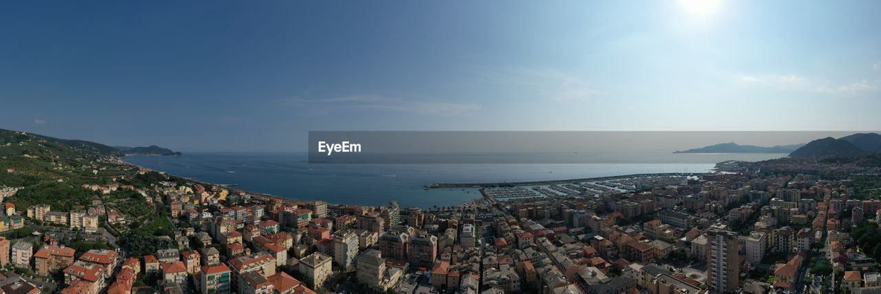 High angle view of townscape by sea against sky