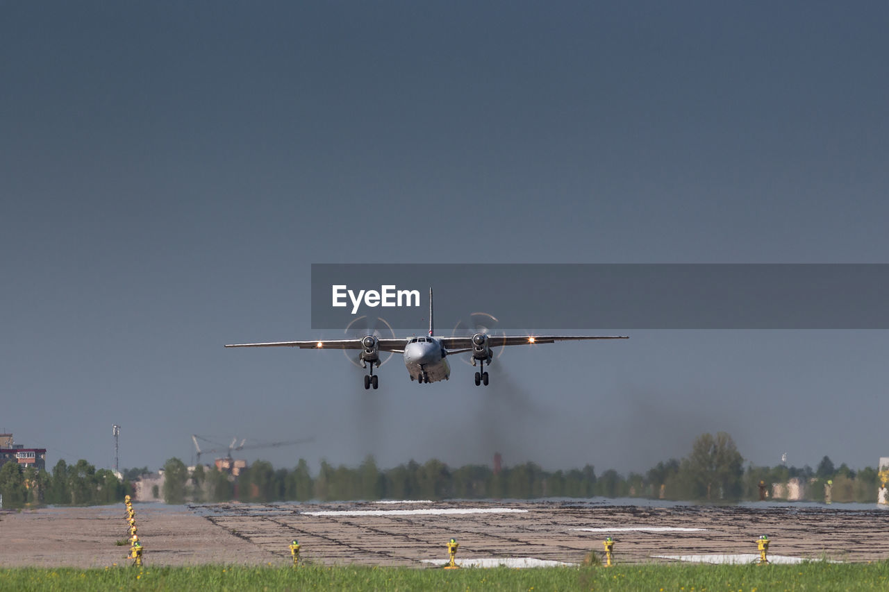 Soviet civil propeller airliner. russian turboprop old aircraft taking off with smoke