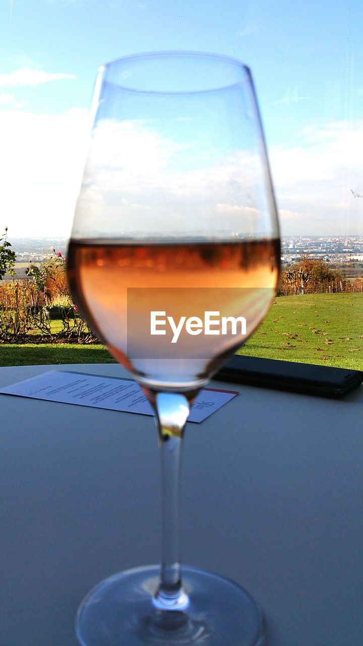 CLOSE-UP OF WINEGLASS AGAINST SKY