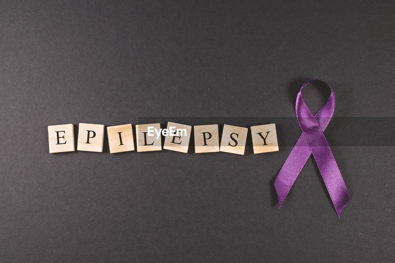 Purple ribbon and epilepsy word on black background. concept of epilepsy awareness