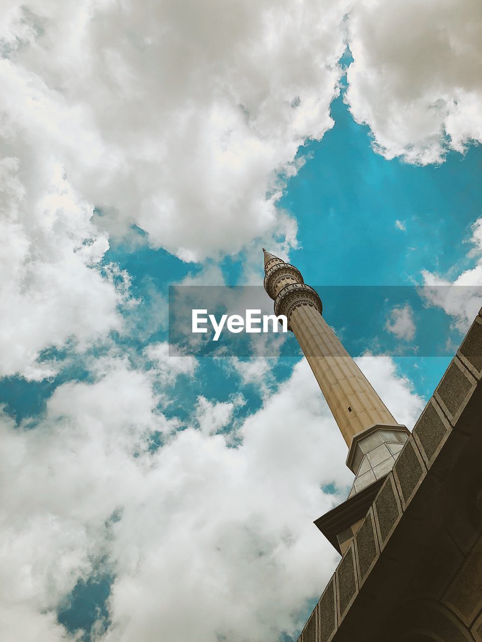 Low angle view of mosque against cloudy sky