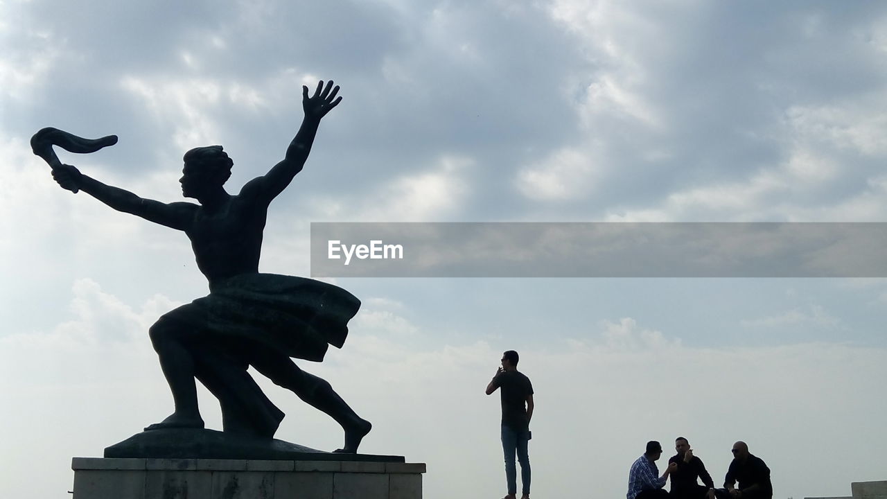 LOW ANGLE VIEW OF SILHOUETTE STATUE IN FRONT OF MONUMENT