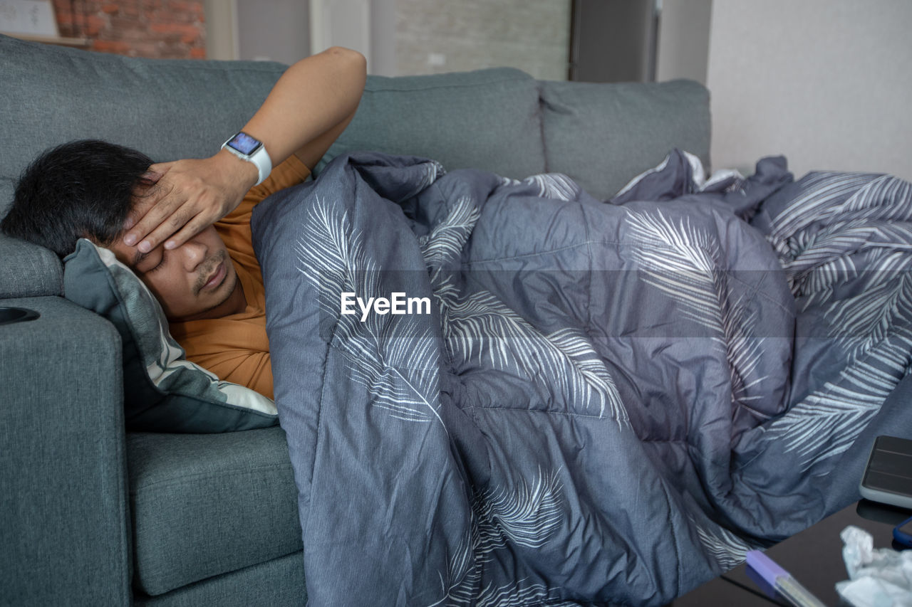 Young man sleeping on sofa at home