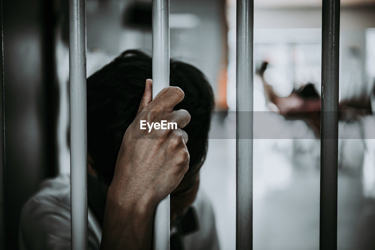 Man standing behind security bar