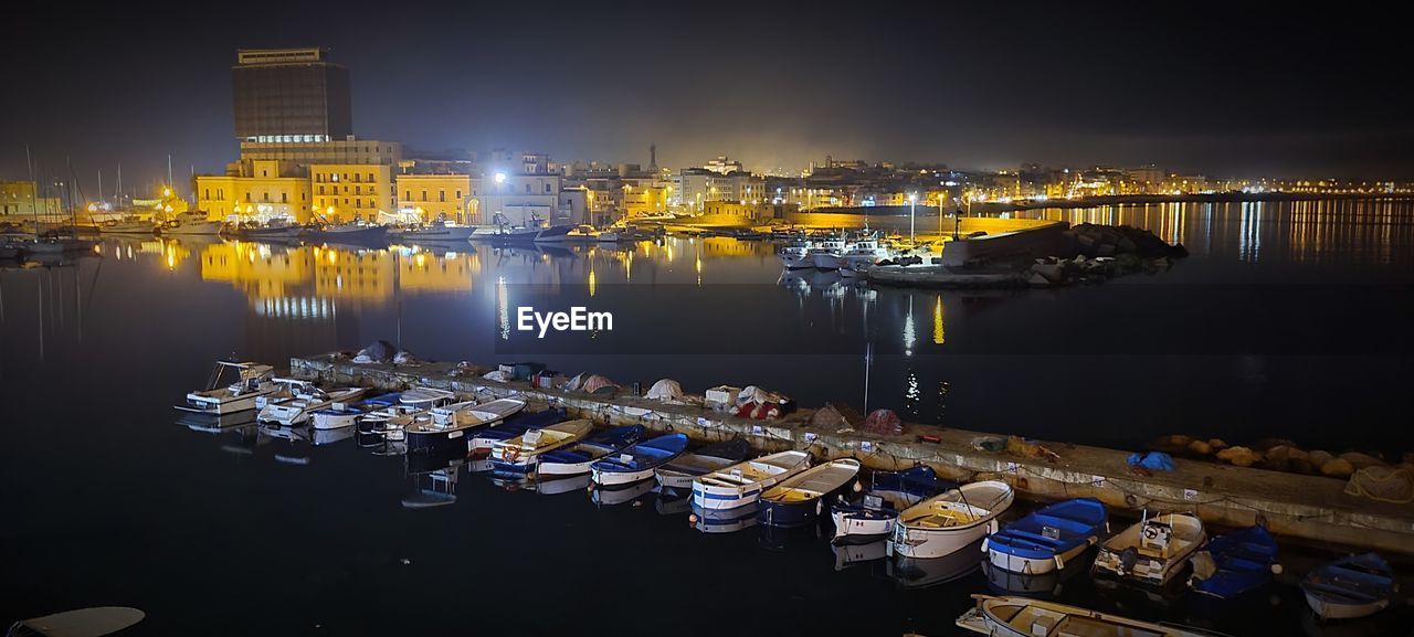 water, reflection, night, marina, nautical vessel, cityscape, architecture, dock, transportation, city, harbor, illuminated, evening, built structure, building exterior, nature, dusk, ship, moored, mode of transportation, no people, sky, vehicle, sea, travel destinations, building, port, outdoors, skyline, boat, travel, business finance and industry, pier, business