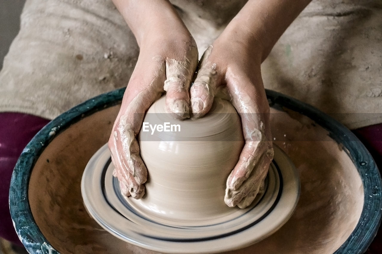 Creating a jar or vase of white clay close-up. master crock. man hands making clay jug macro. 