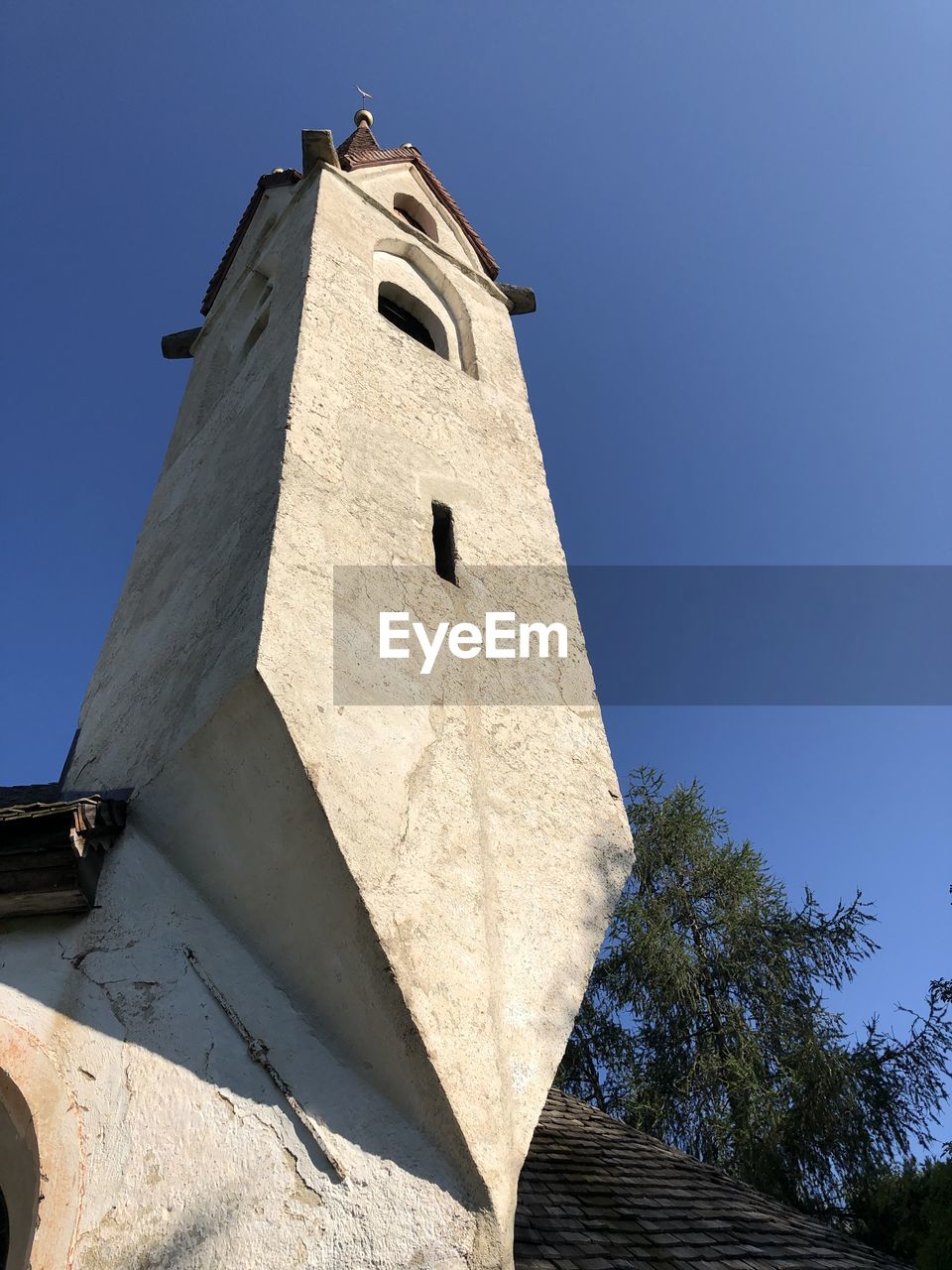 Low angle view of small church against clear blue sky