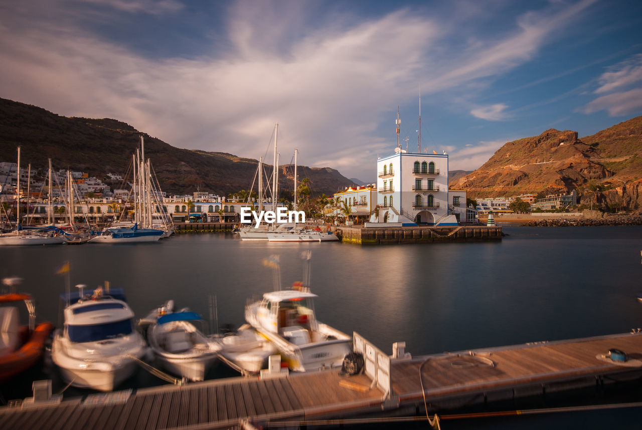 BOATS MOORED IN SEA AGAINST BUILDINGS