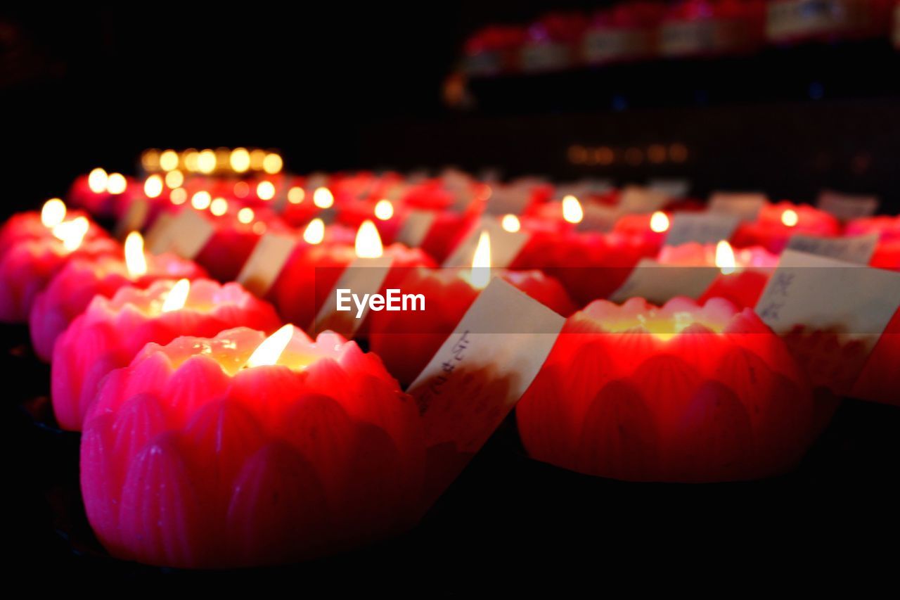 Close-up of burning candles in shape of lotus flowers