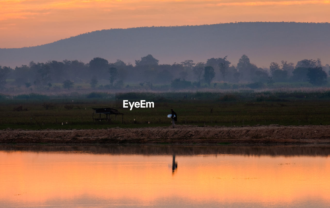 SCENIC VIEW OF LAKE AT SUNSET