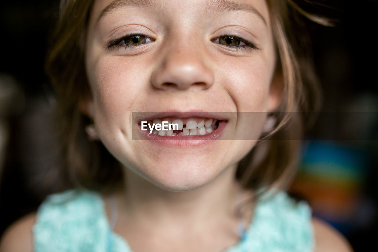 Close-up portrait of girl showing gap tooth