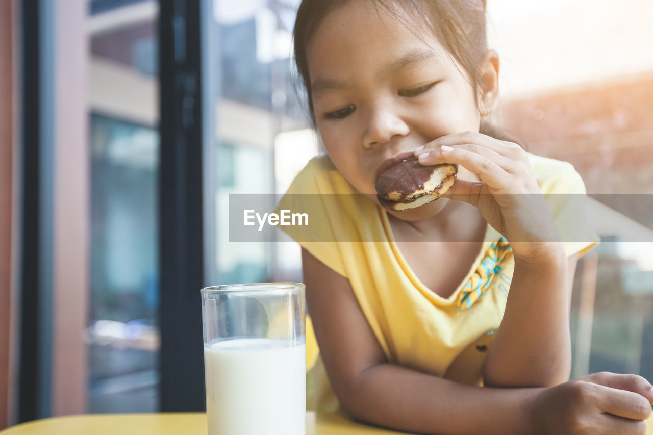 Close-up of girl eating food on table at home