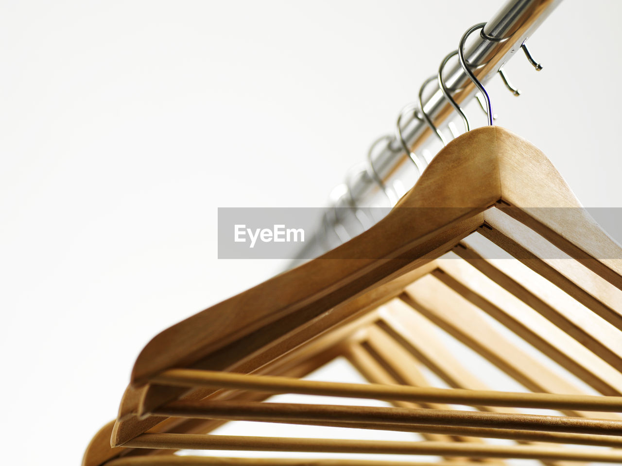 Low angle view of cloth hanger against white background 