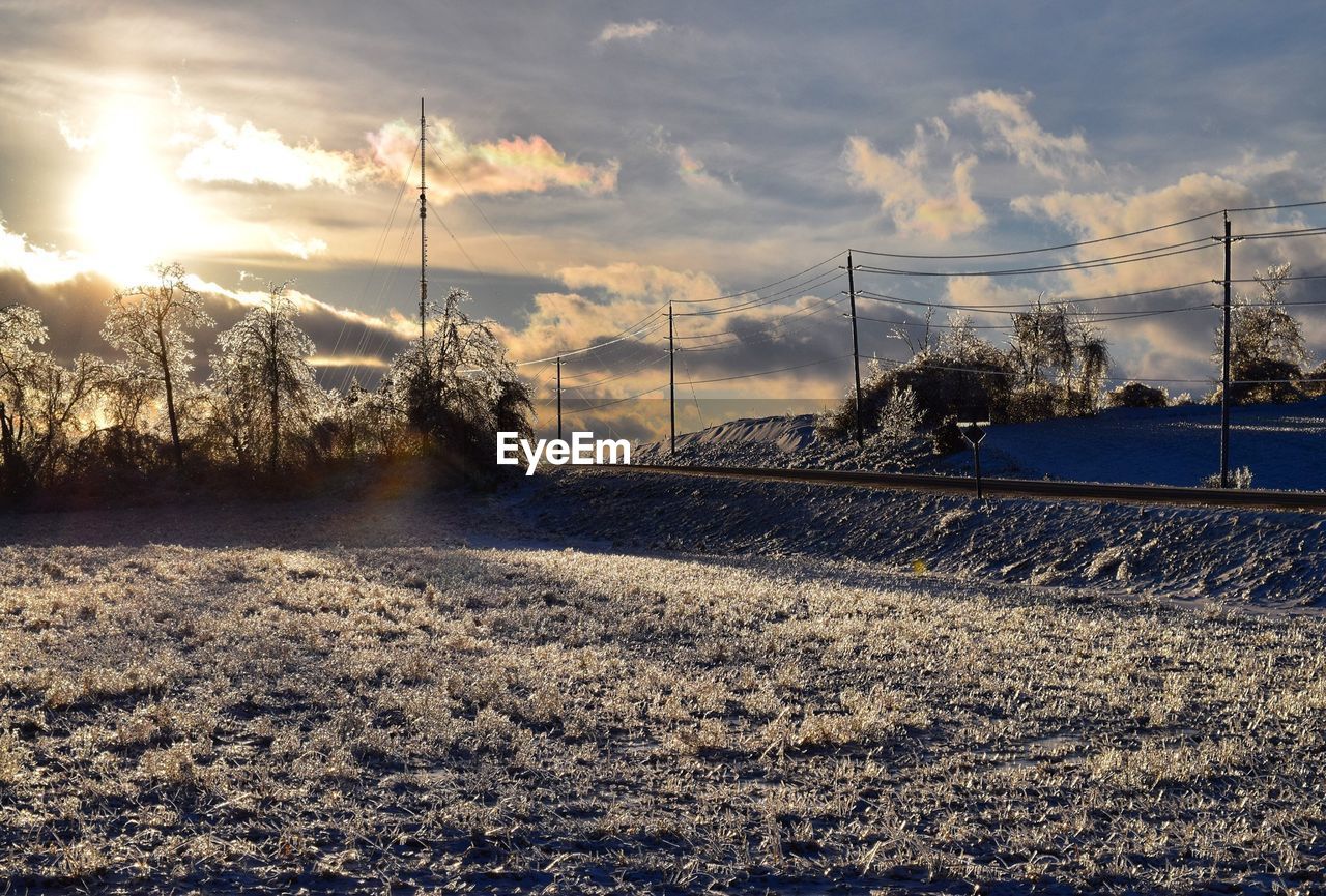 Scenic view of landscape against cloudy sky during winter