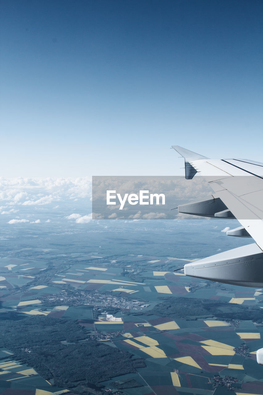 Airplane flying over landscape against sky