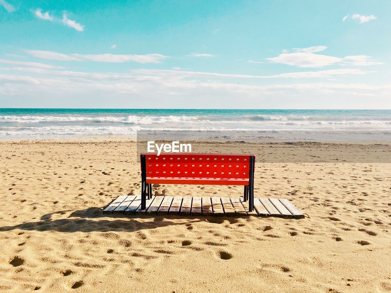 Chair on beach against sky