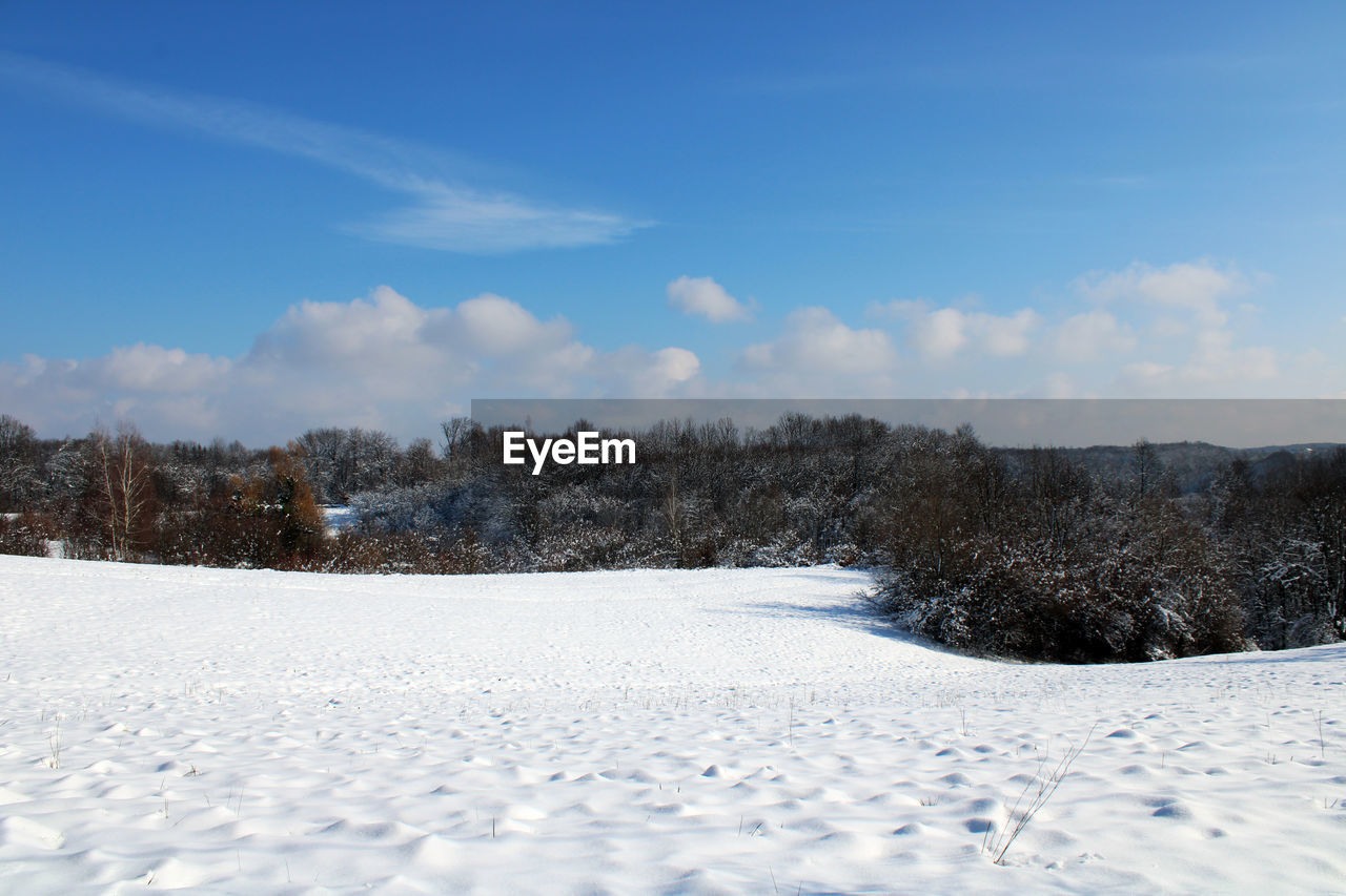 SNOW COVERED LAND AGAINST SKY