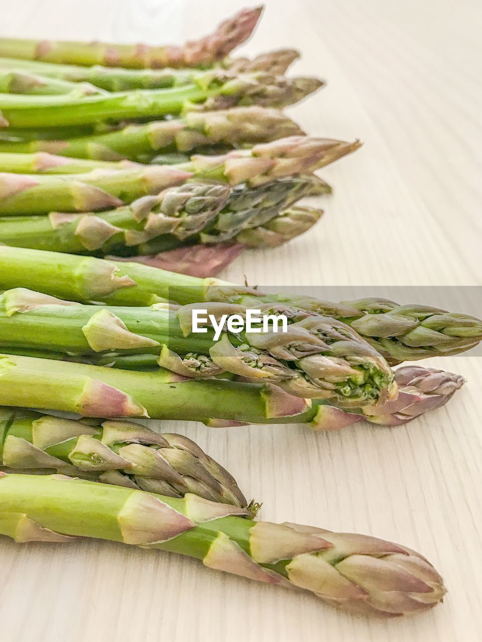 High angle view of green asparagus on light wood underground 