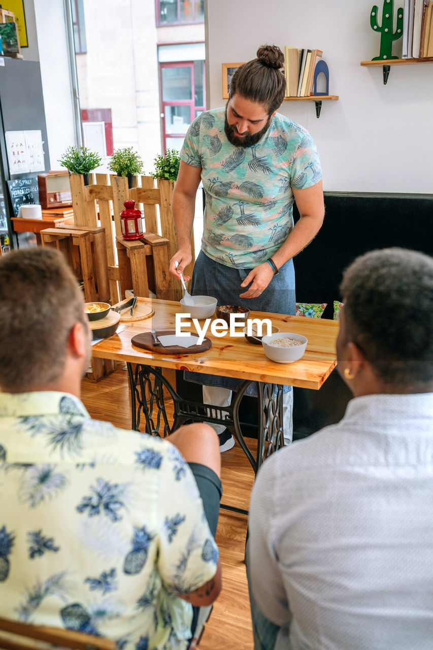 Rear view of people sitting at restaurant table