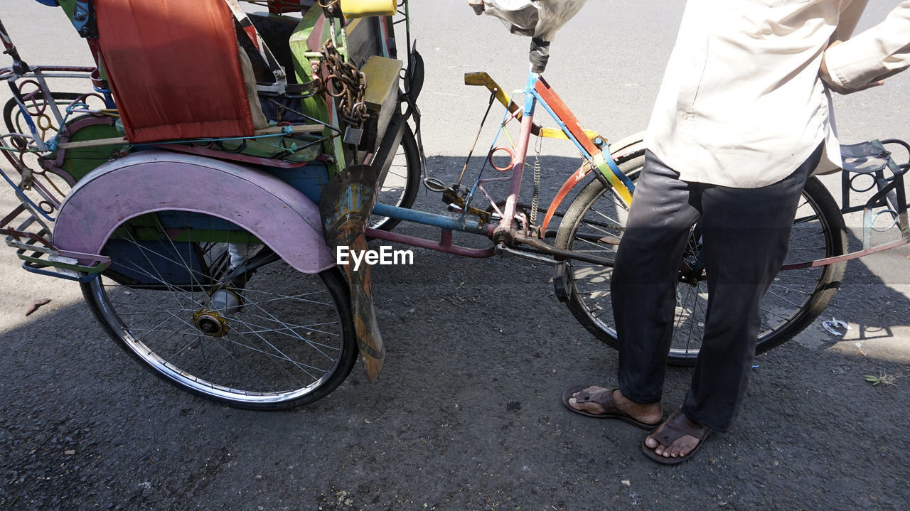 LOW SECTION OF MAN WEARING BICYCLE ON STREET