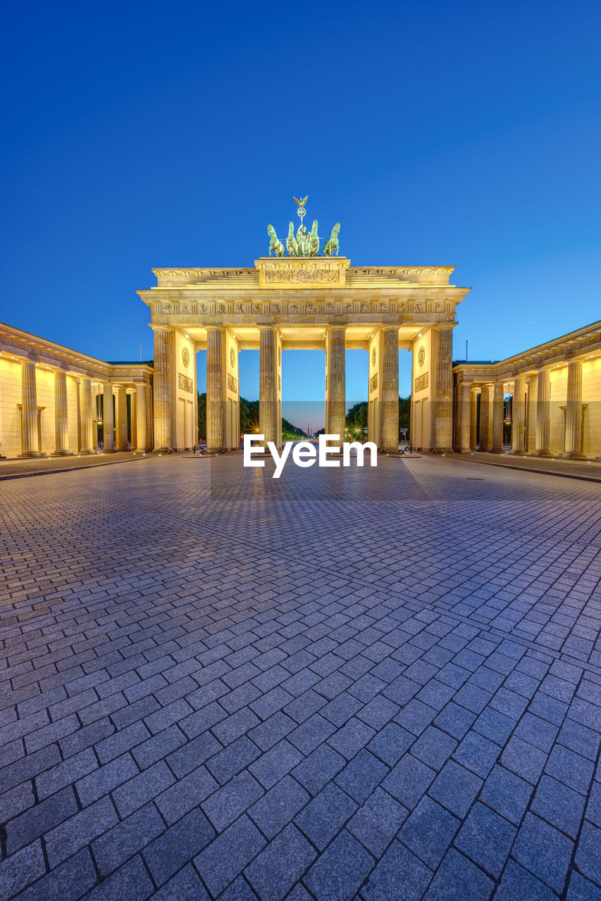 The illuminated brandenburg gate in berlin at dusk with no people