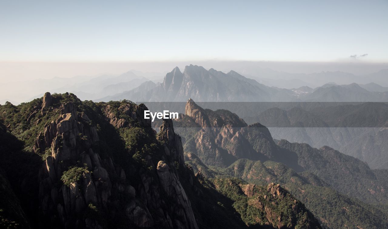 Idyllic shot of mountains against sky during foggy weather