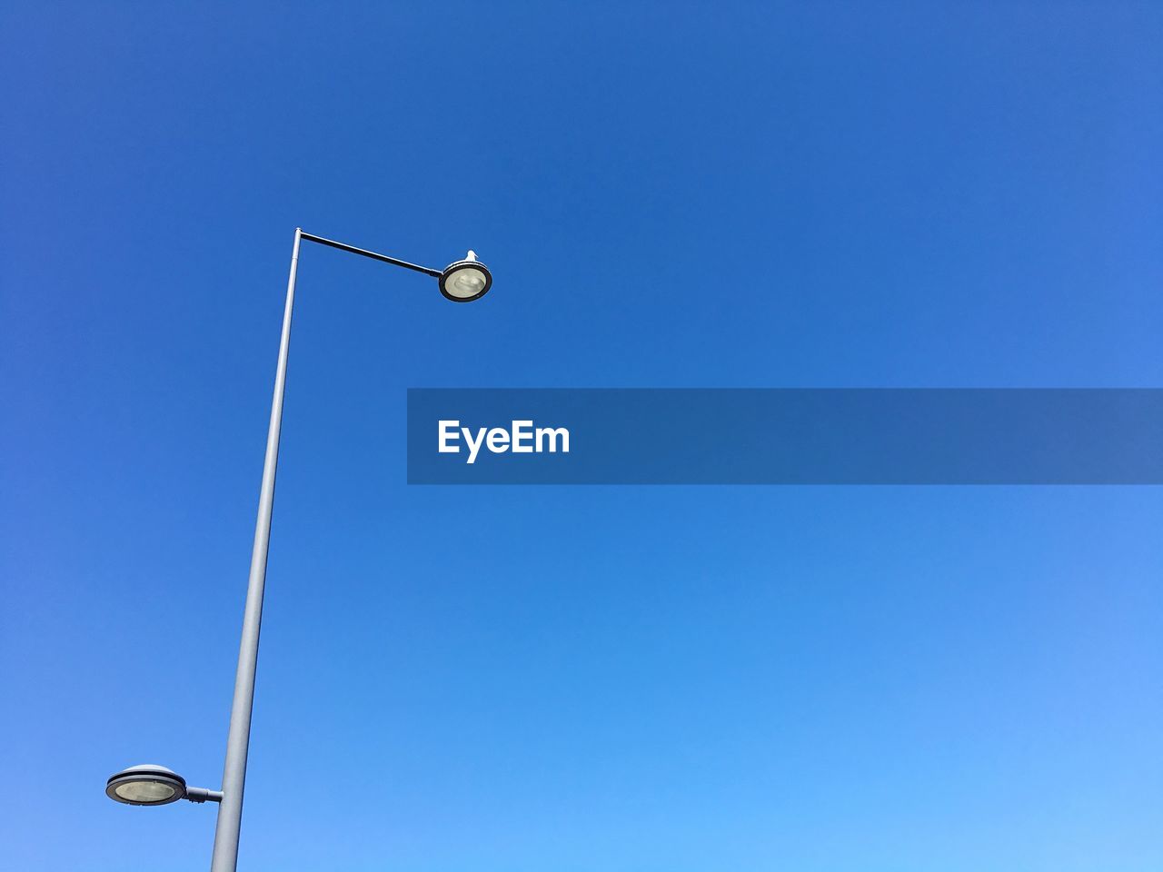 Low angle view of street light against clear blue sky