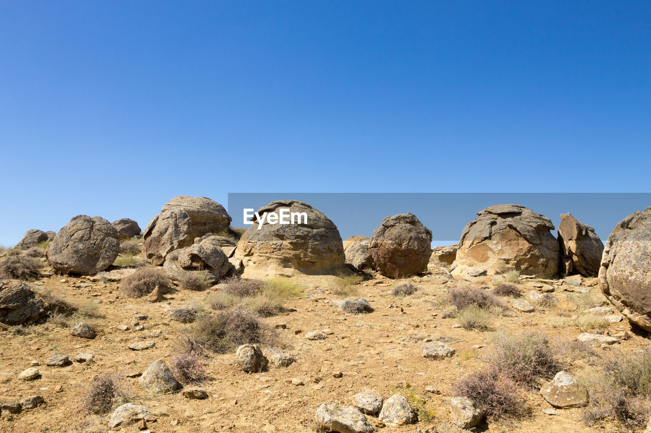 rock formations on landscape against clear blue sky
