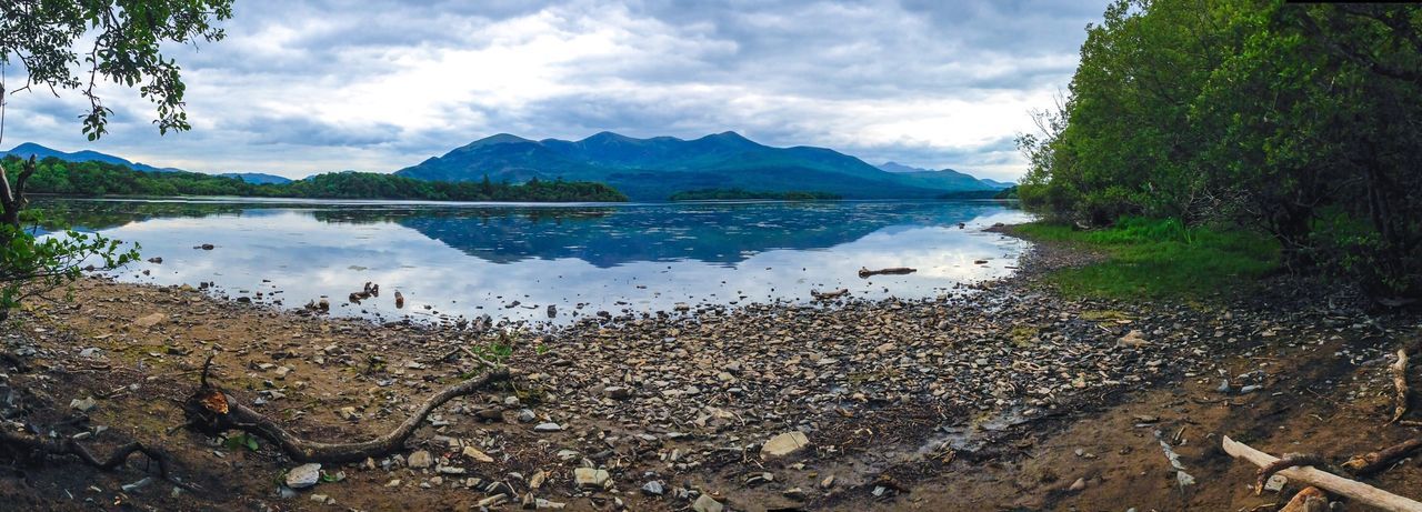 Scenic view of lake and mountains against cloudy sky