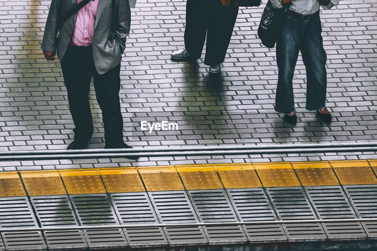 Low section of people waiting for a train at the station platform