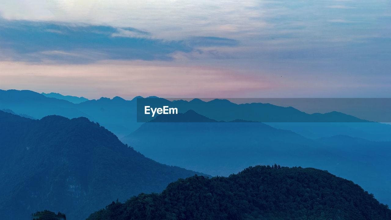 Scenic view of mountains against sky at dawn