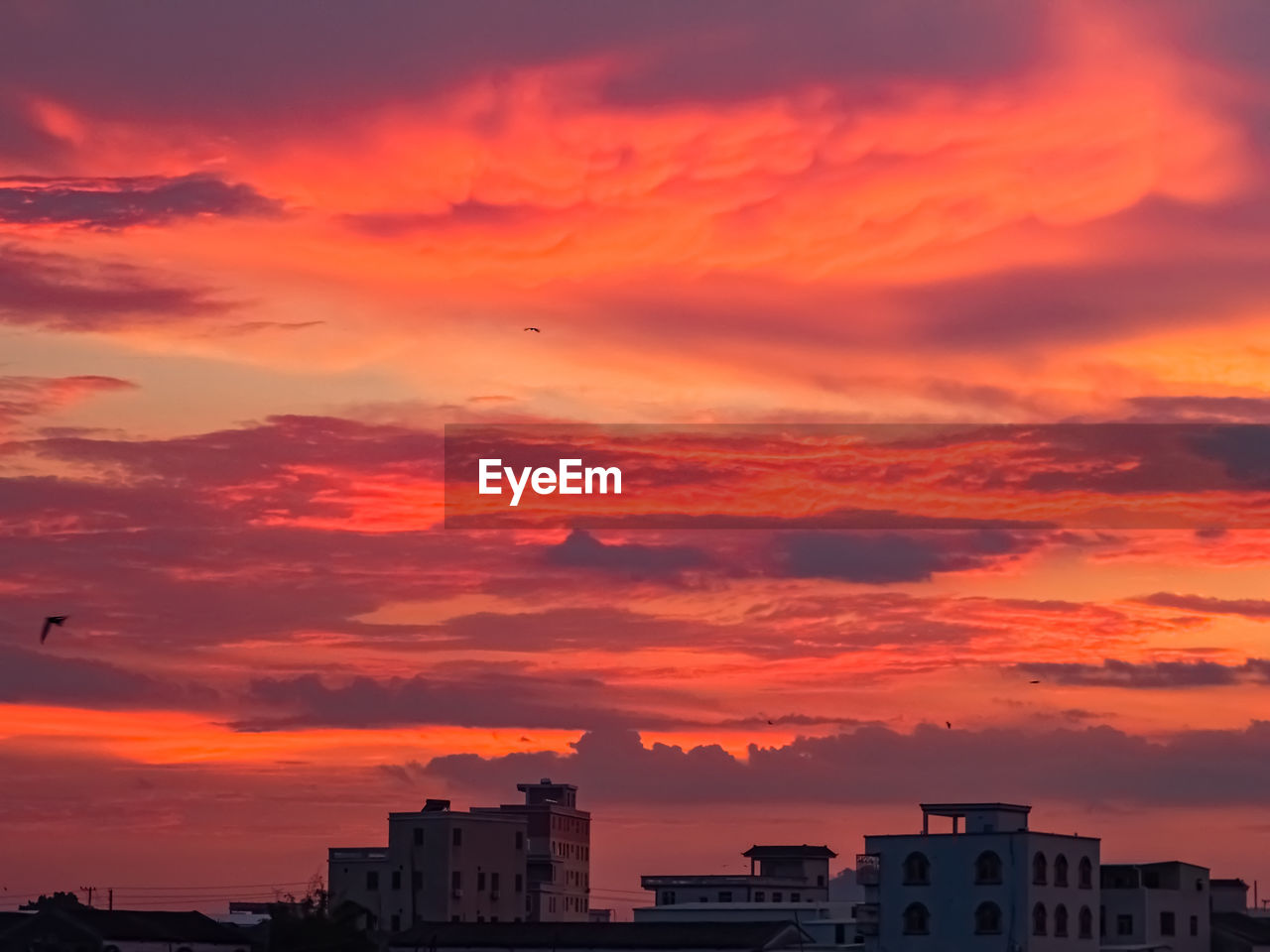 Silhouette buildings against sky during sunset