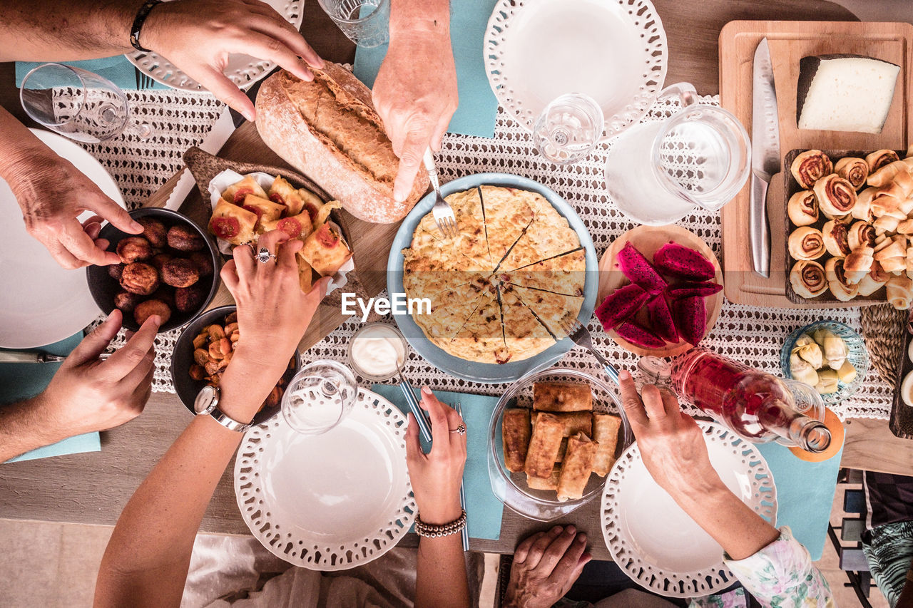 High angle view of people having food on dining table