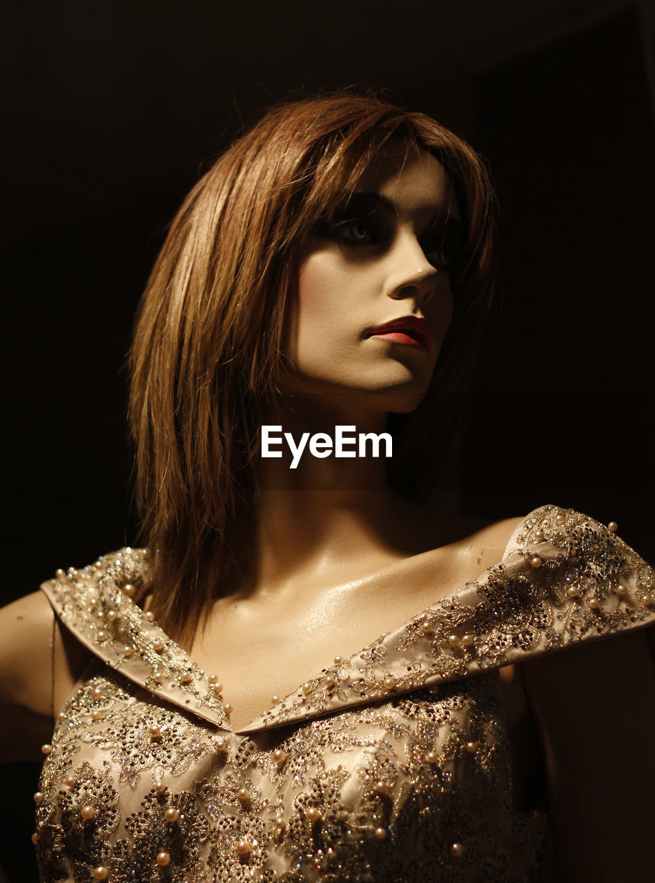 Close-up of mannequin against black background