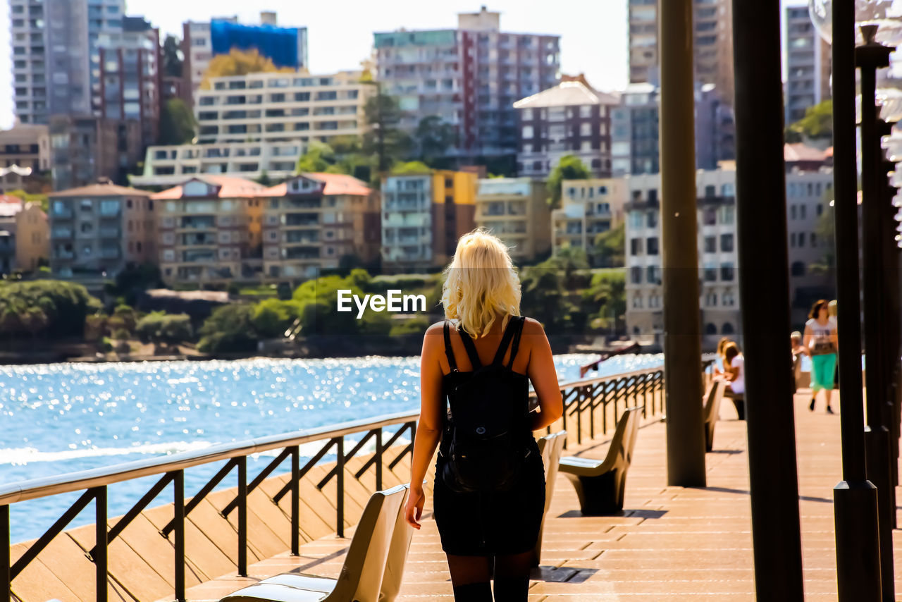 REAR VIEW OF WOMAN LOOKING AT VIEW