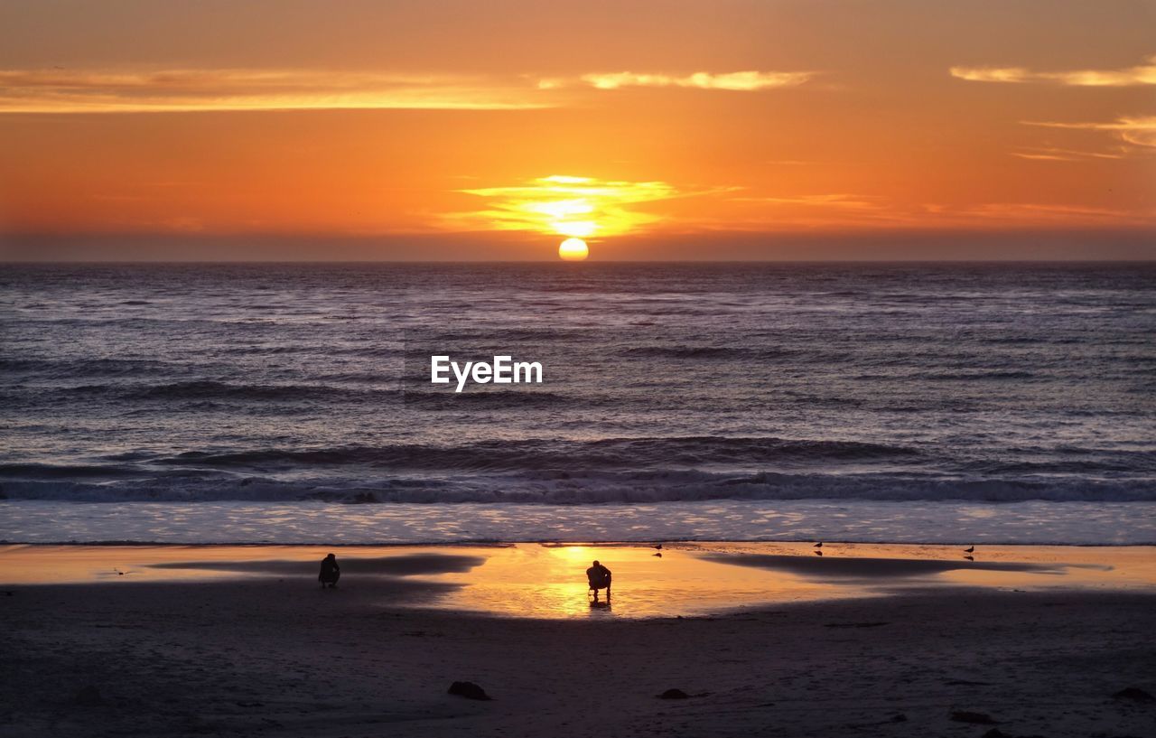 Scenic view of beach against sky during sunset