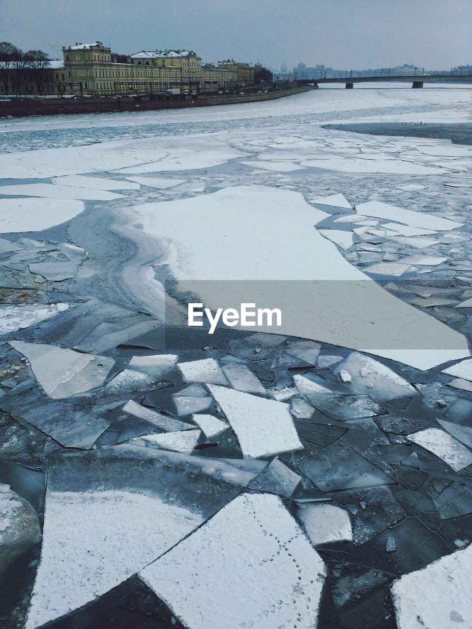 View of frozen river with building in background